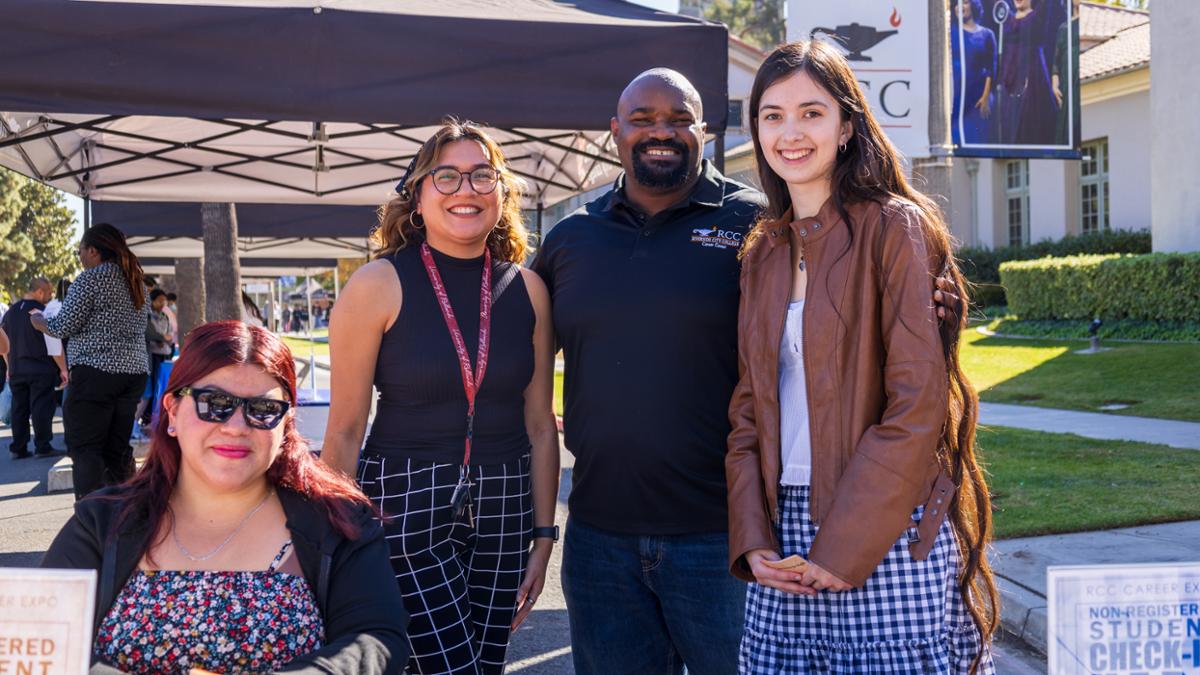 Career Center staff smiling in front of tents for the career expo