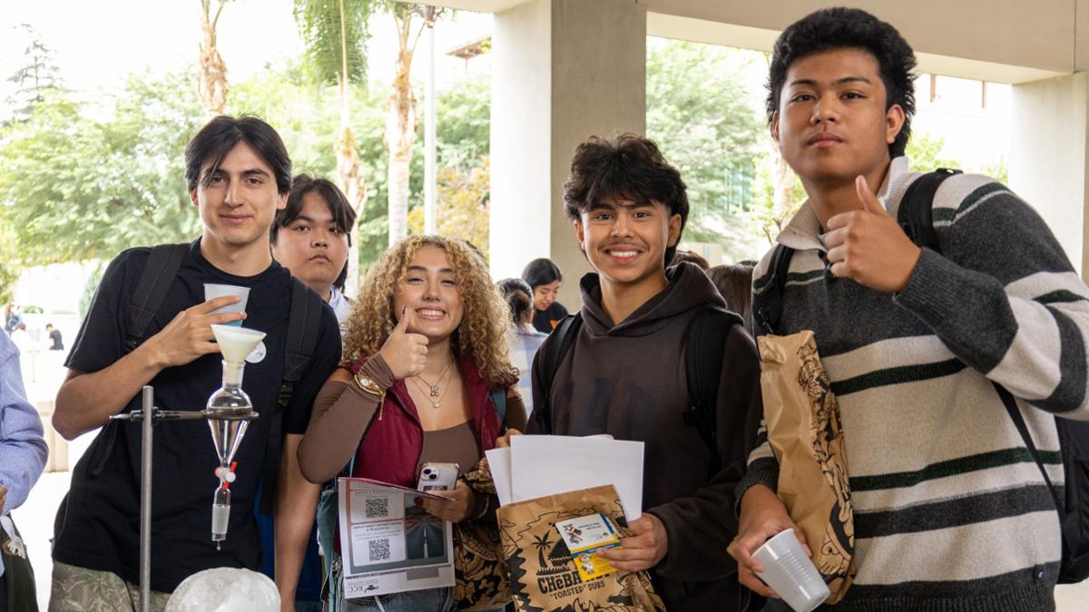 Four Students at a table smiling for the camera