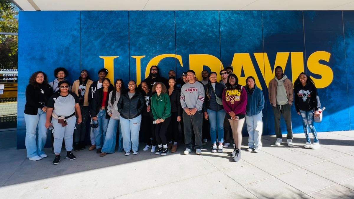 Umoja Students in front of a college building sing for UC Davis