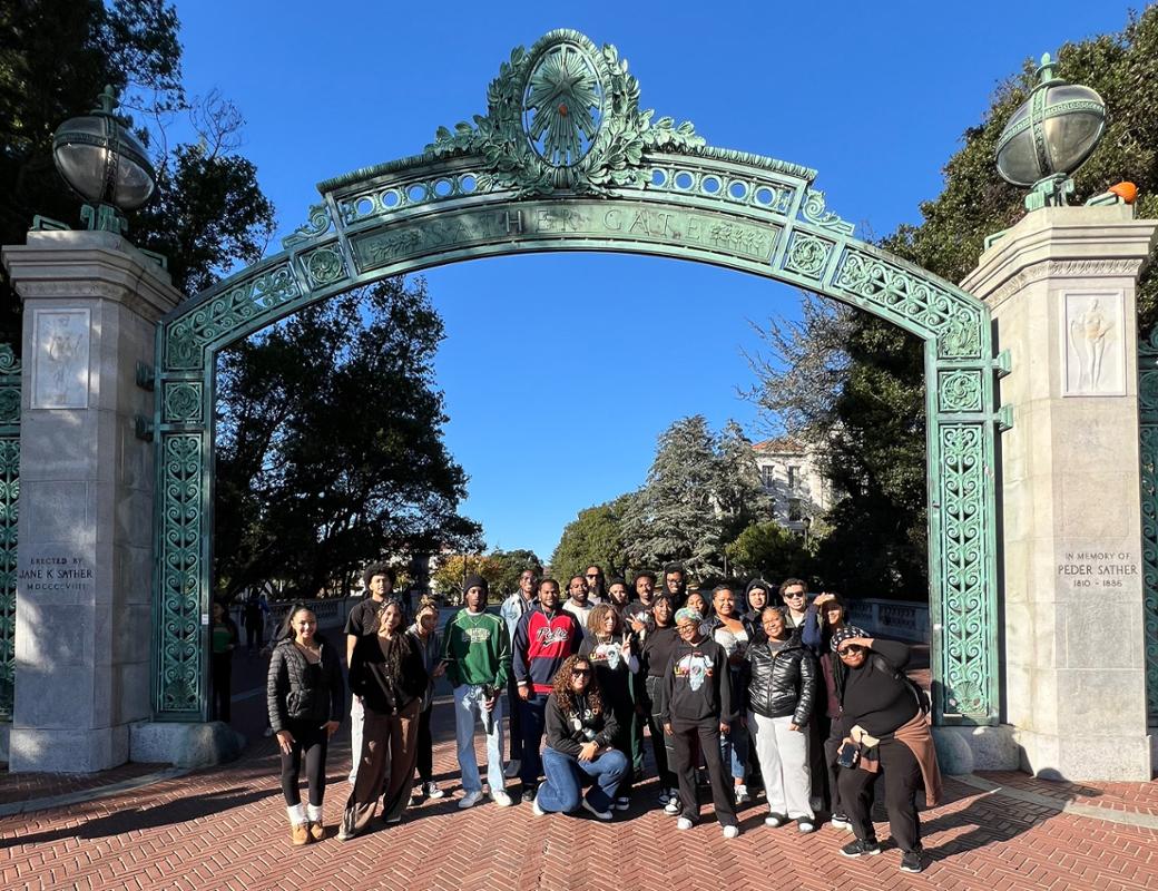 Umoja Students in front of a college building arch