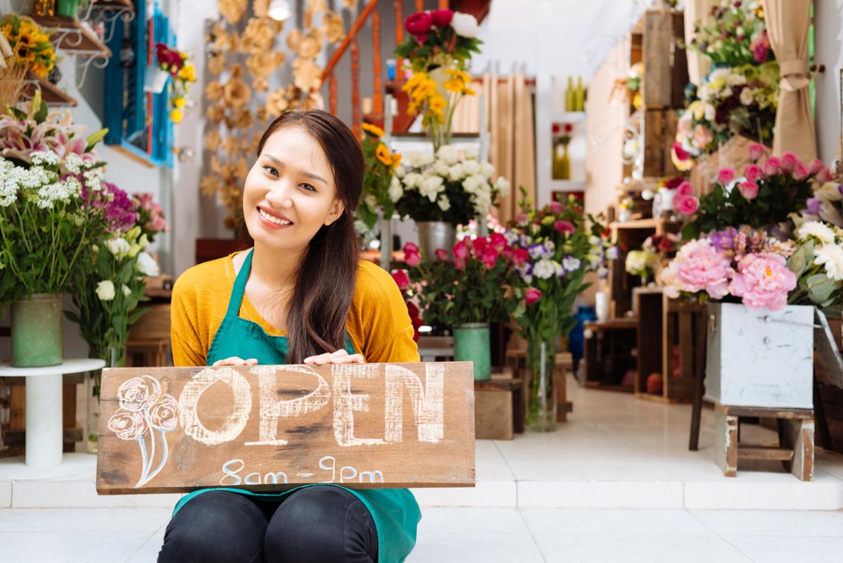 Person smiling in front of a small business