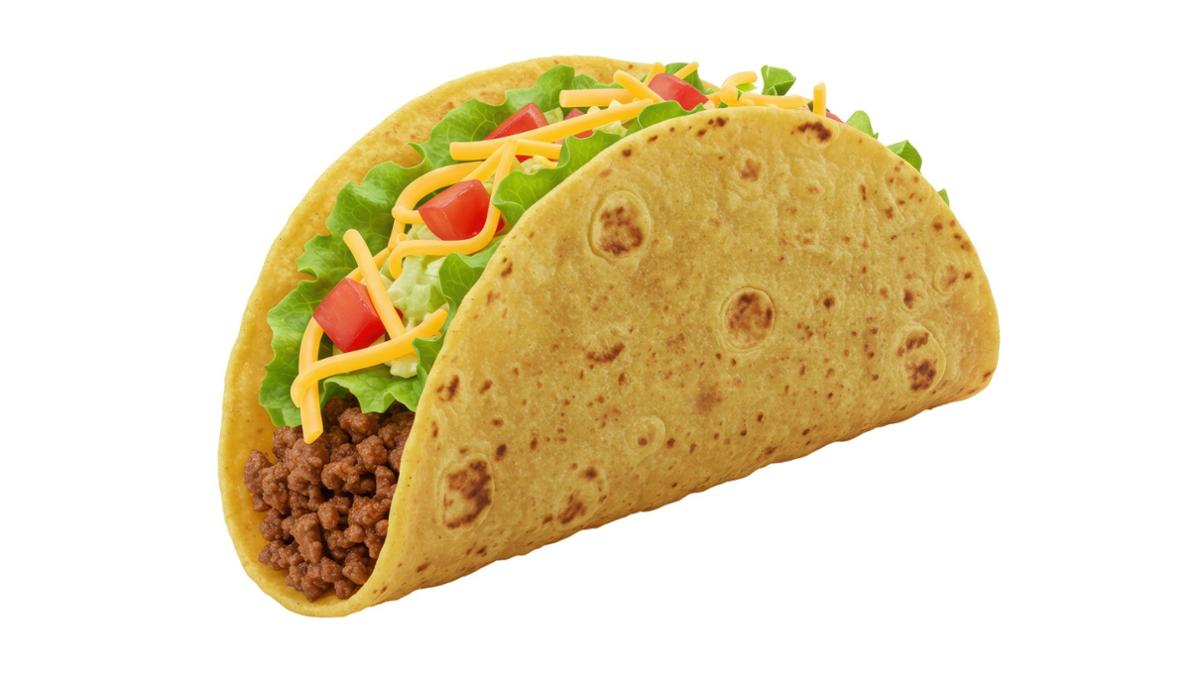 Taco Hard taco shell filled with seasoned ground beef, shredded lettuce, diced tomatoes, and shredded cheddar cheese on a white background.