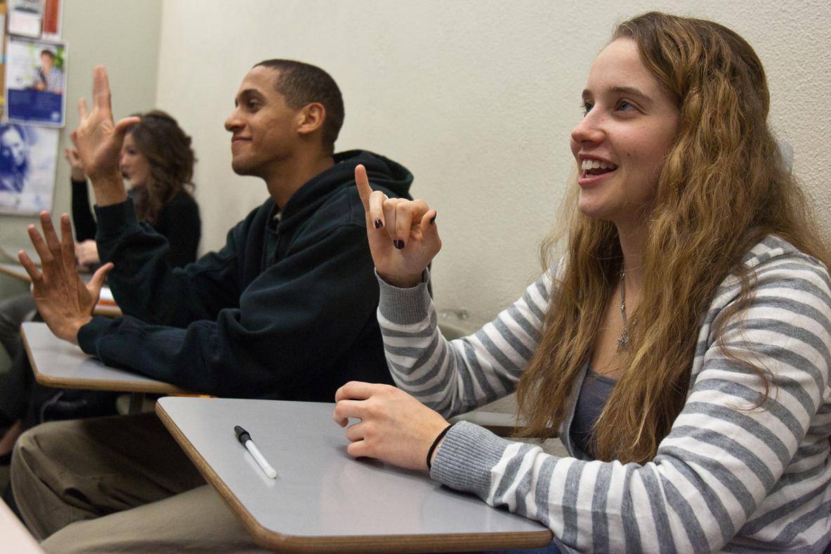 Students in classroom doing sign language